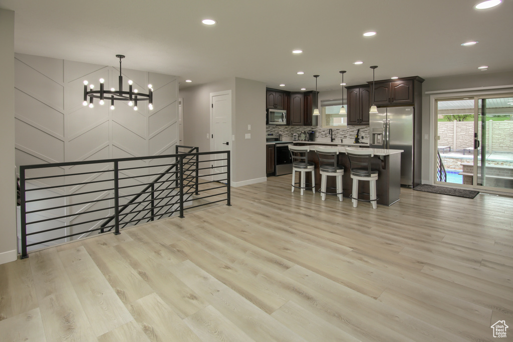 Dining area with a chandelier, light wood-style flooring, recessed lighting, and baseboards
