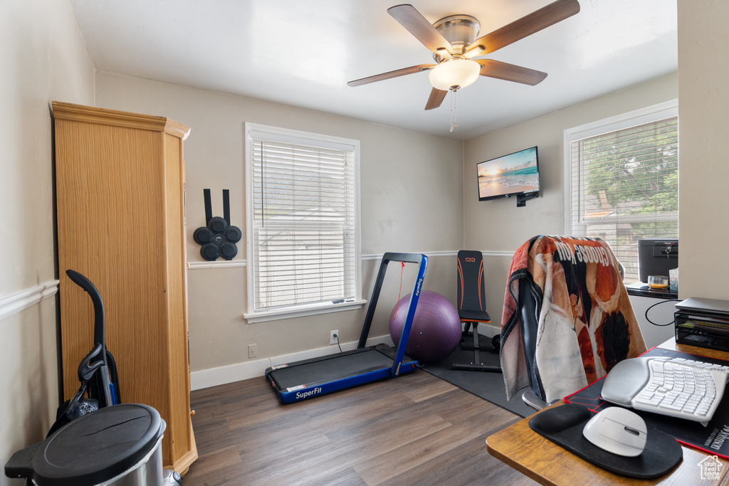 Home office with wood finished floors, a ceiling fan, and baseboards