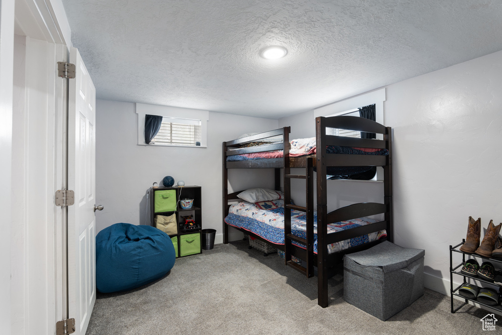 Bedroom with a textured ceiling and carpet flooring
