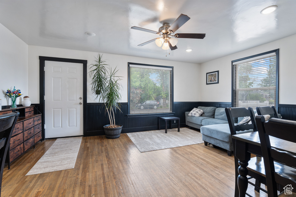 Living room featuring plenty of natural light, a wainscoted wall, a ceiling fan, wood finished floors, and recessed lighting
