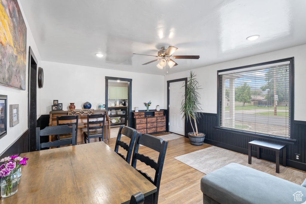 Dining area featuring wainscoting, wood finished floors, a ceiling fan, and recessed lighting
