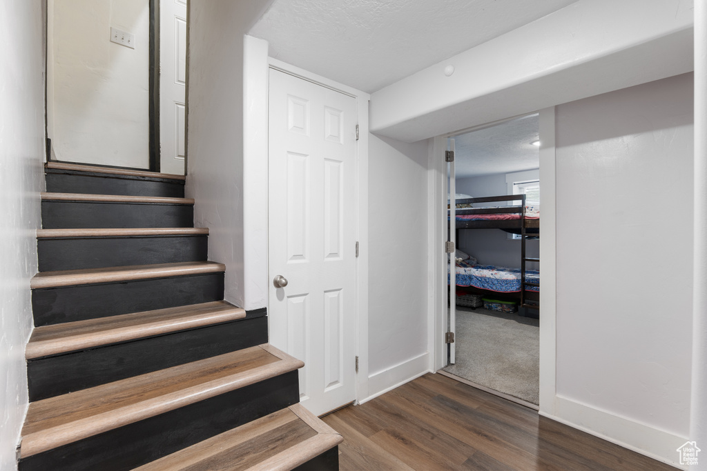 Staircase with wood finished floors and baseboards