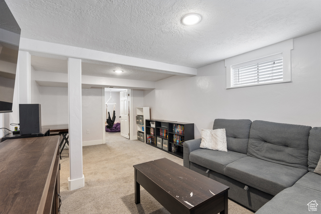 Carpeted living area with a textured ceiling and baseboards