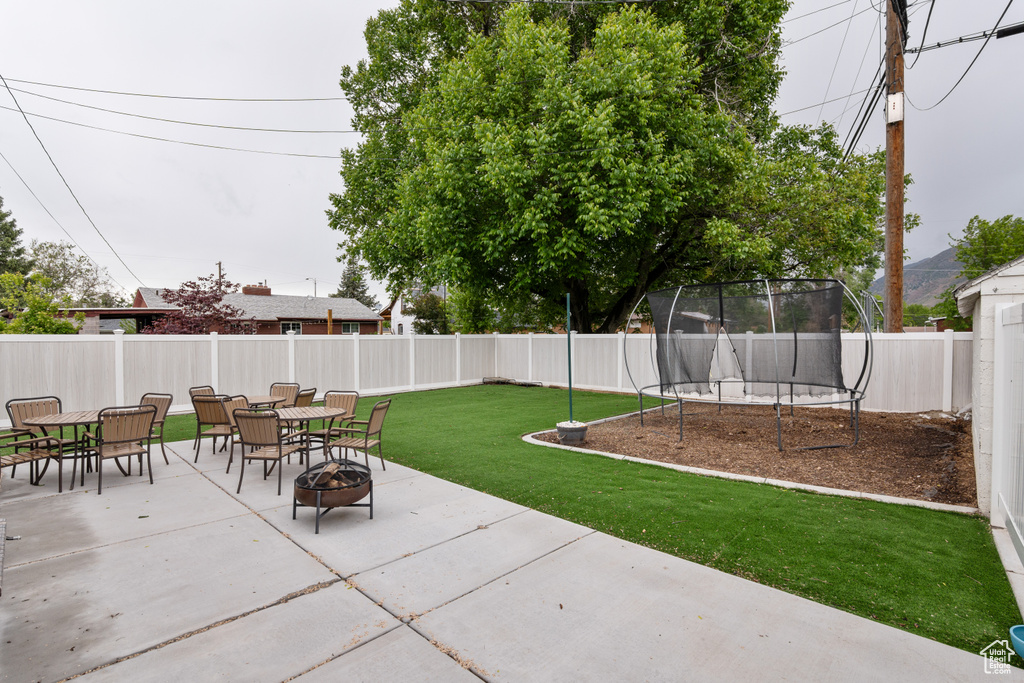 View of patio / terrace featuring a trampoline, an outdoor fire pit, and outdoor dining space