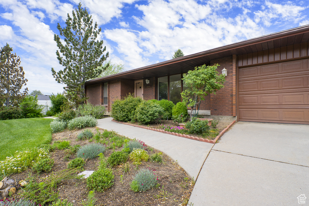 View of front of home featuring brick siding, an attached garage, and concrete driveway