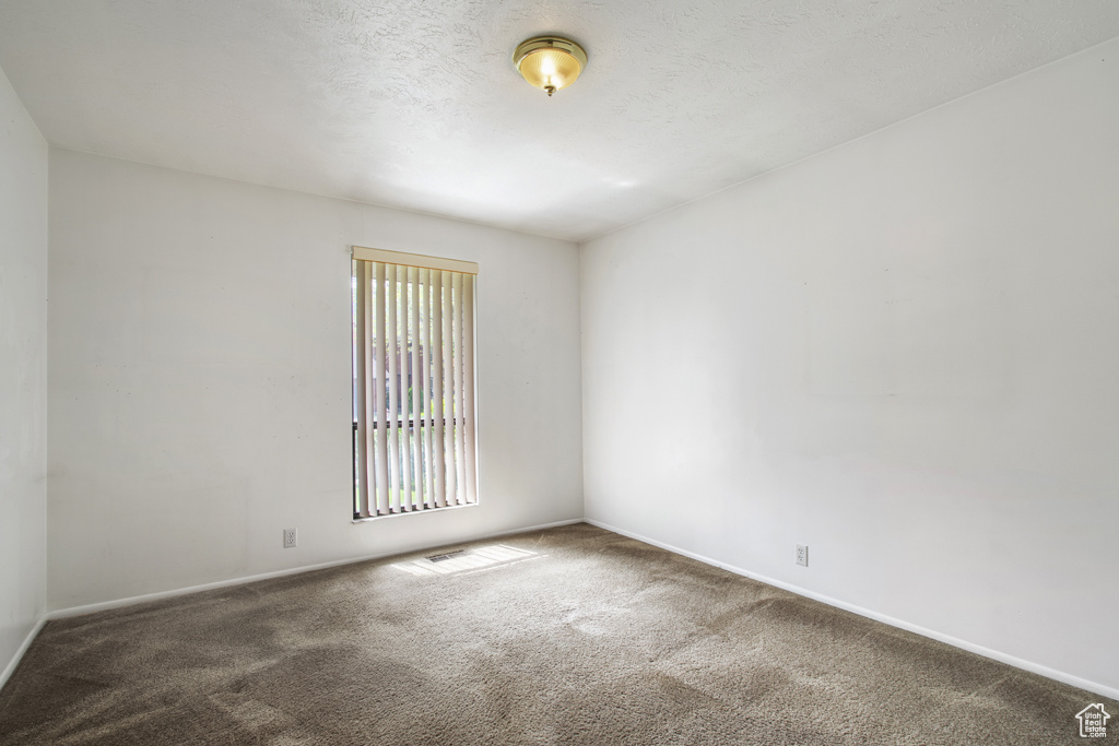Unfurnished room featuring carpet floors and baseboards