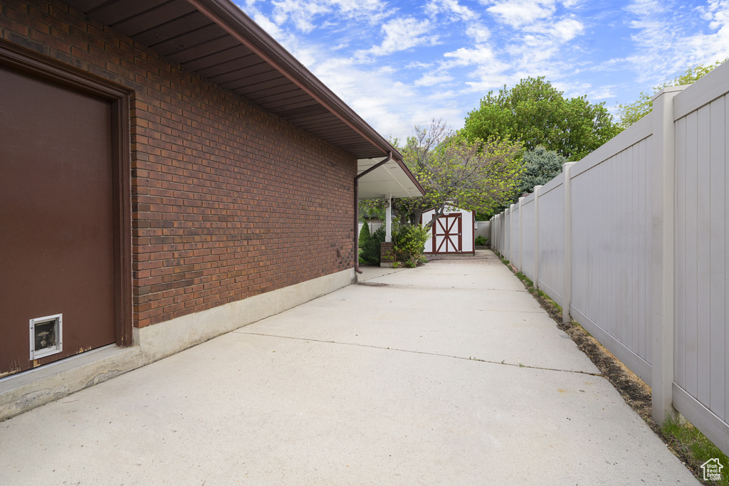View of patio featuring a storage shed, a fenced backyard, and an outdoor structure