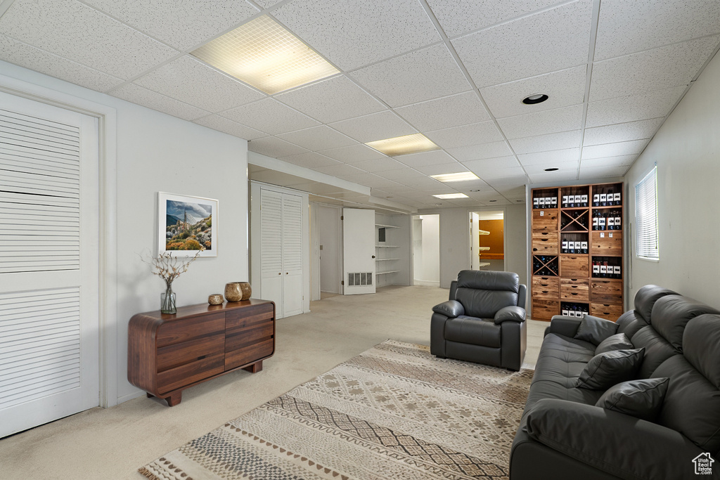 Living room with light colored carpet and a paneled ceiling