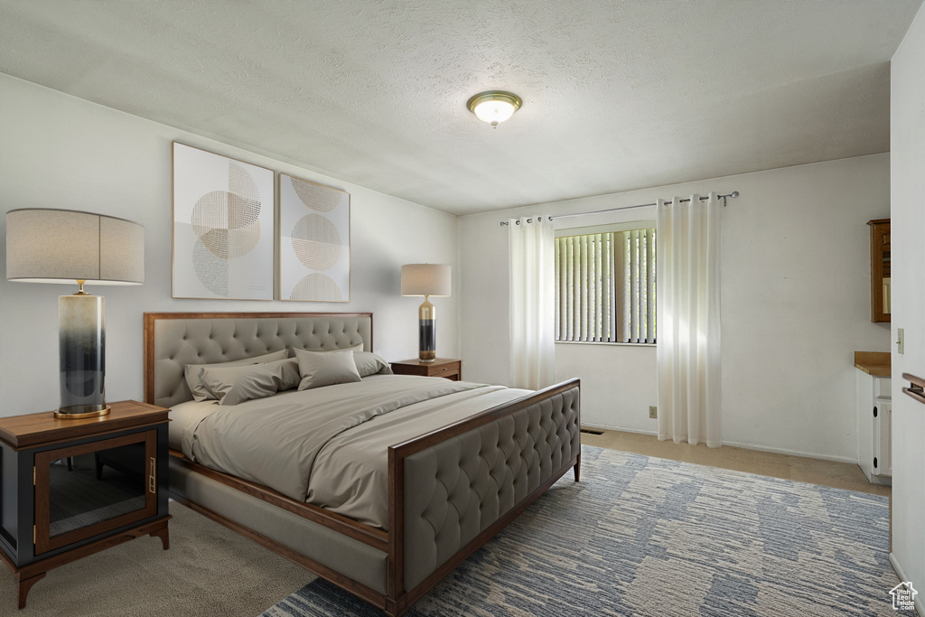 Bedroom with carpet flooring, a textured ceiling, and baseboards