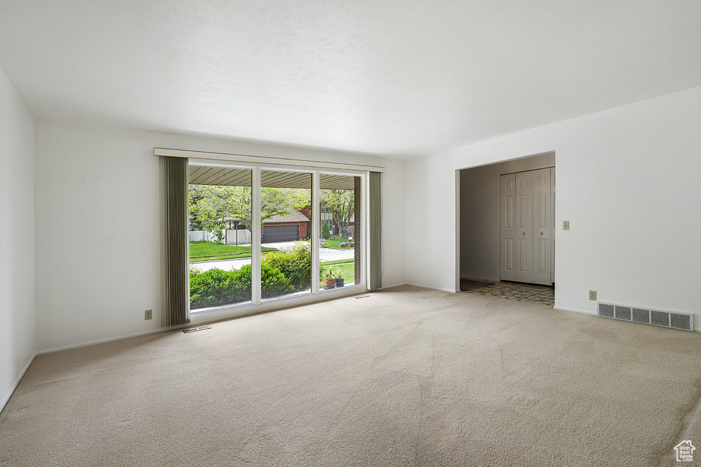 Spare room featuring carpet and baseboards