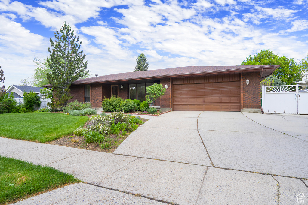 View of front of property with a garage, brick siding, and concrete driveway