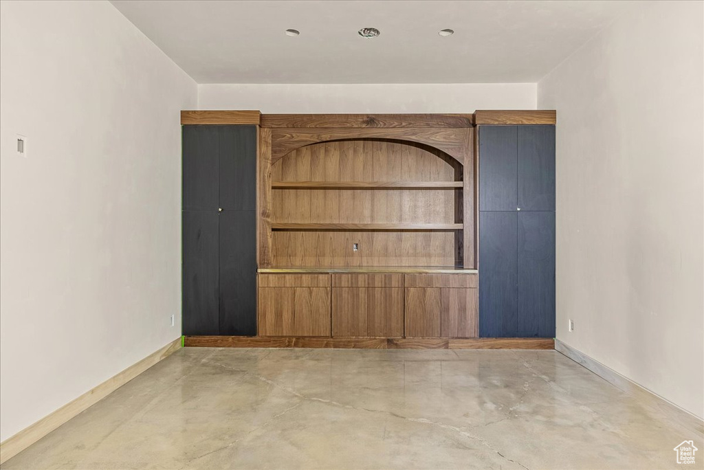 Unfurnished room with concrete floors and baseboards