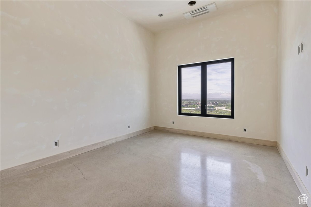 Unfurnished room featuring concrete floors and baseboards
