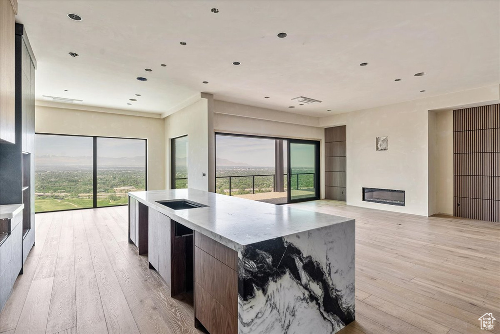 Kitchen featuring open floor plan, modern cabinets, light wood-style flooring, and recessed lighting