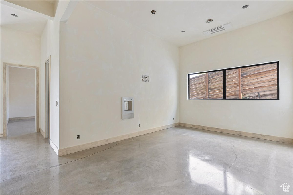 Empty room with finished concrete floors and baseboards