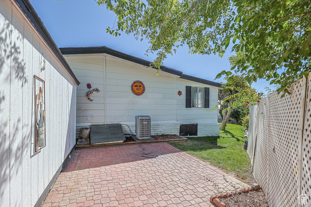 View of patio with cooling unit and fence