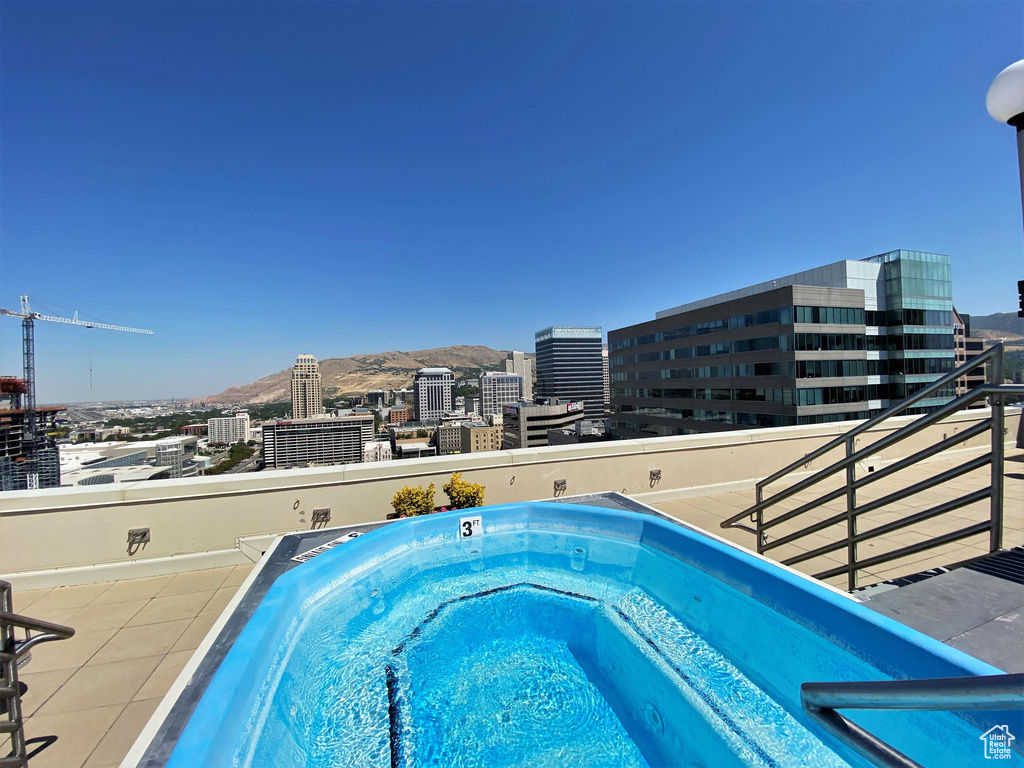View of pool featuring a view of city and an outdoor hot tub