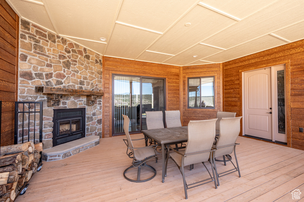 Wooden terrace featuring a stone fireplace and outdoor dining area