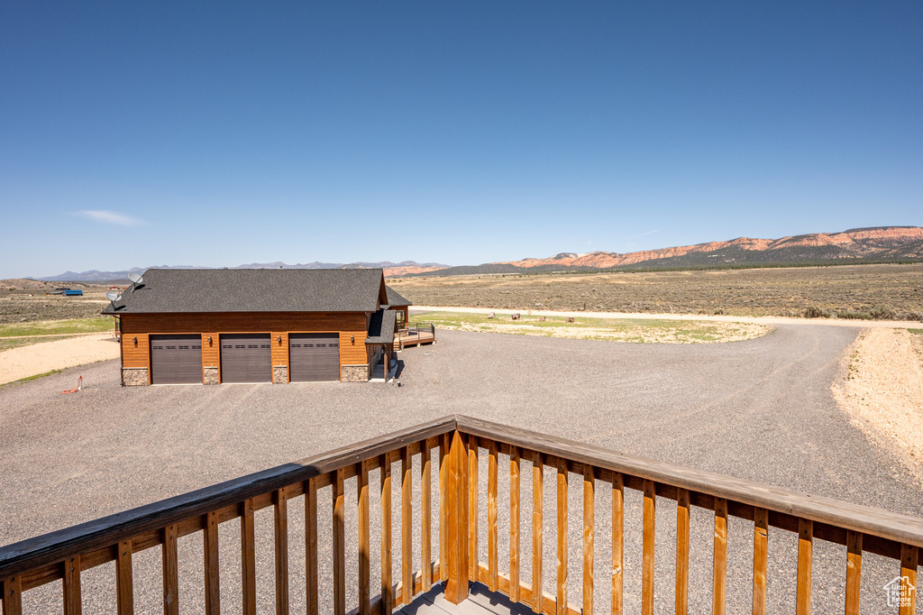 Wooden deck featuring a mountain view and a garage