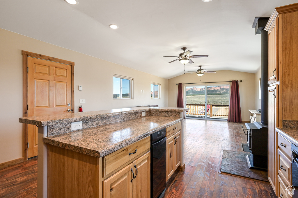 Kitchen with vaulted ceiling, a ceiling fan, dark wood-type flooring, a center island, and recessed lighting