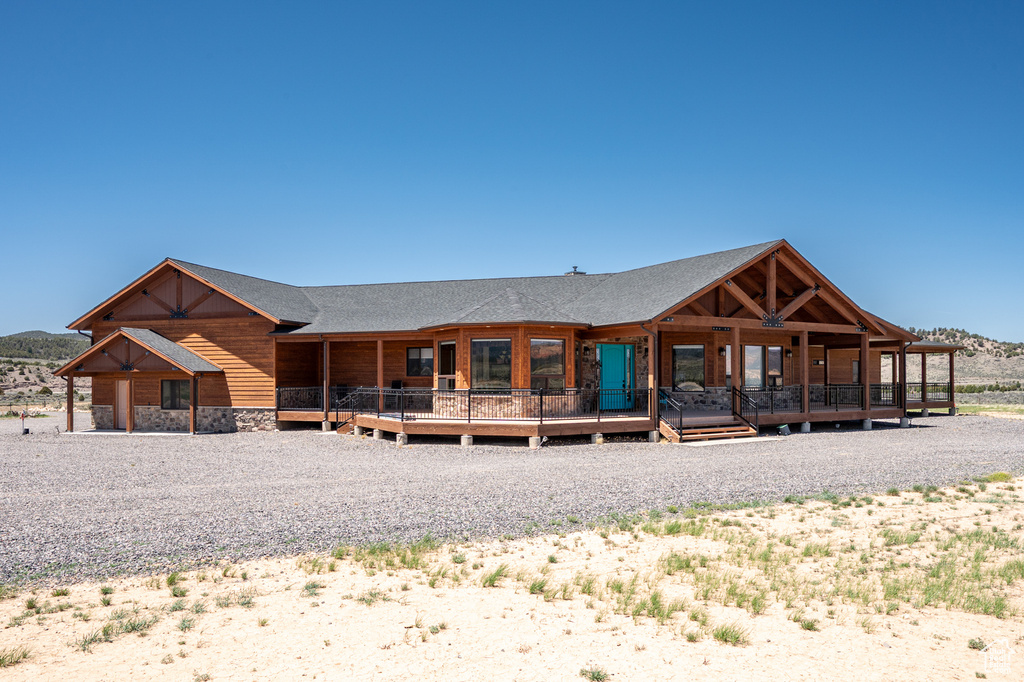 View of front of house with stone siding and roof with shingles