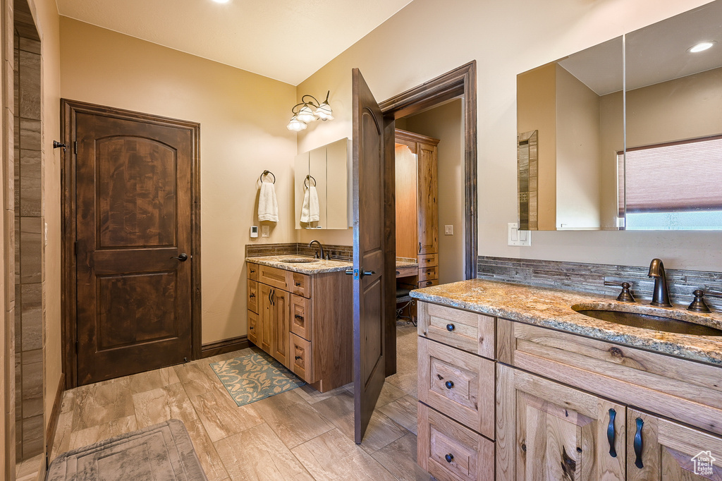 Bathroom featuring two vanities and recessed lighting
