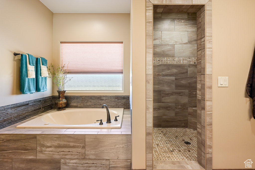 Bathroom with a tile shower and a garden tub