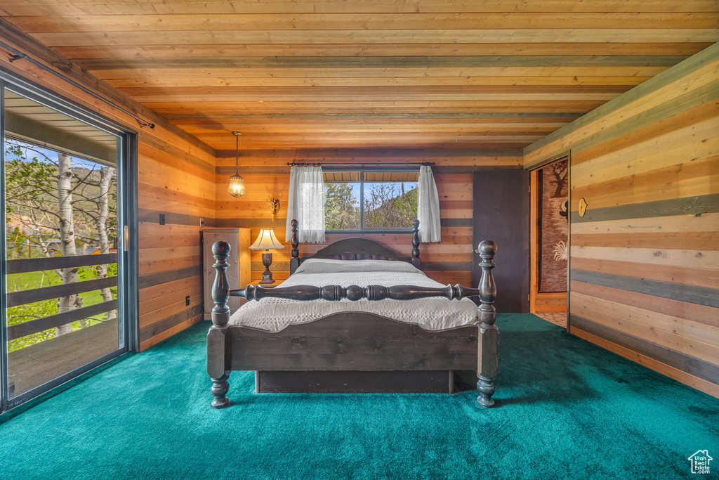 Bedroom featuring wooden ceiling, carpet floors, and wood walls