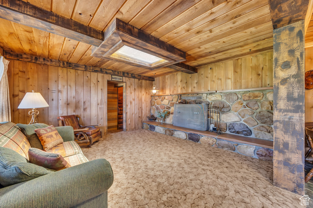 Living room featuring wood ceiling, wood walls, and beamed ceiling