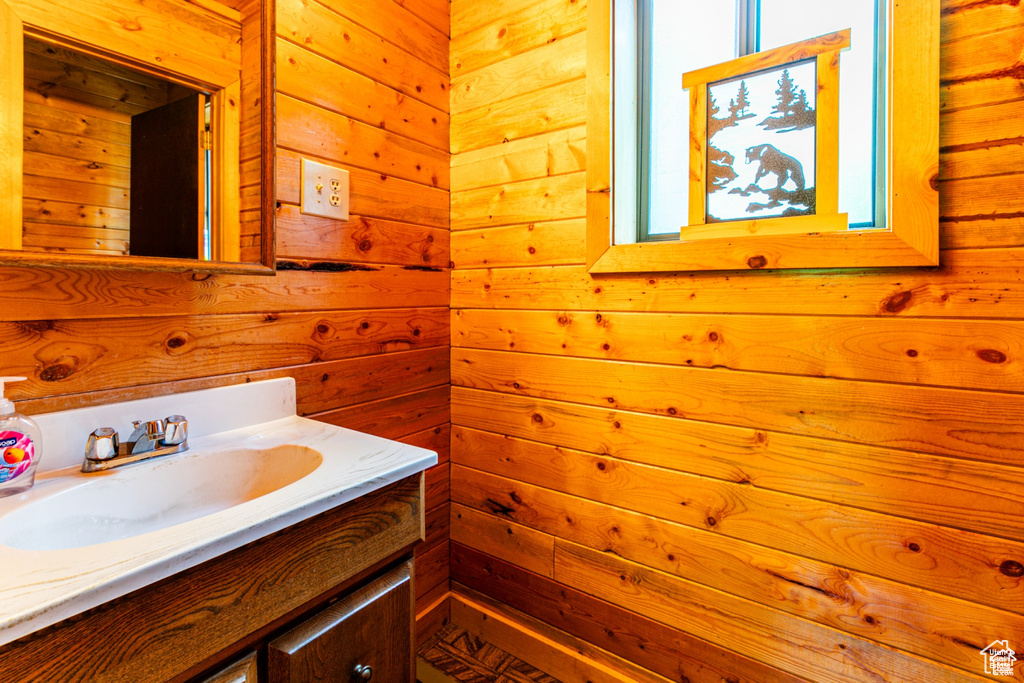 Bathroom featuring wood walls and vanity