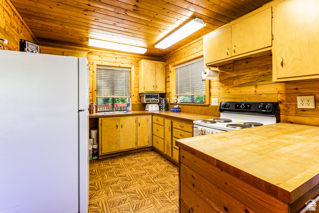 Kitchen featuring white appliances, wooden ceiling, wood walls, wood counters, and a sink