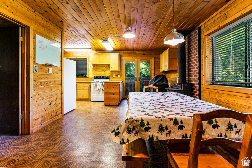 Bedroom with freestanding refrigerator, french doors, wooden walls, wood ceiling, and a wood stove