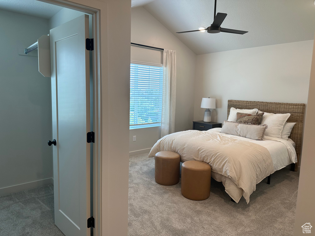 Bedroom with carpet flooring, vaulted ceiling, baseboards, and a ceiling fan