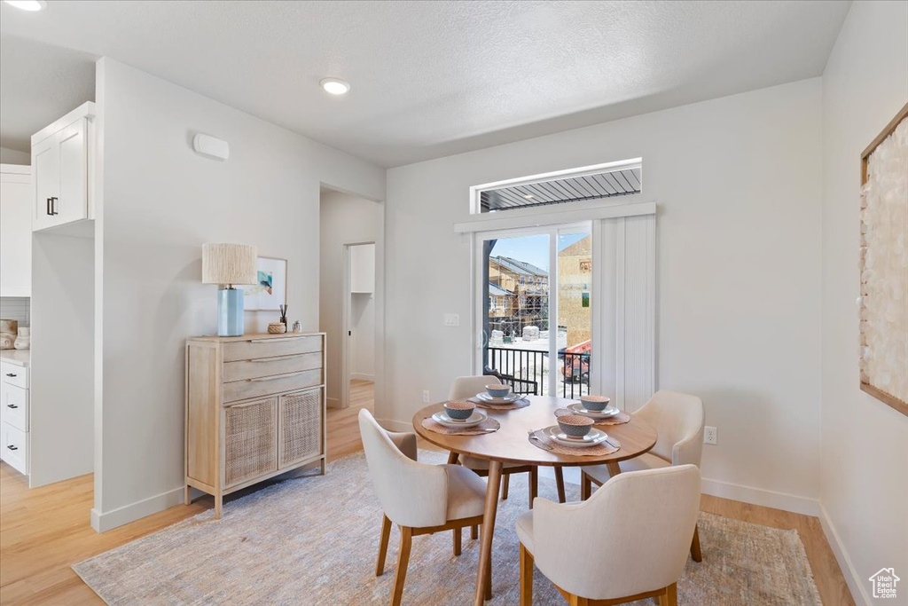 Dining room with light wood-style flooring and recessed lighting