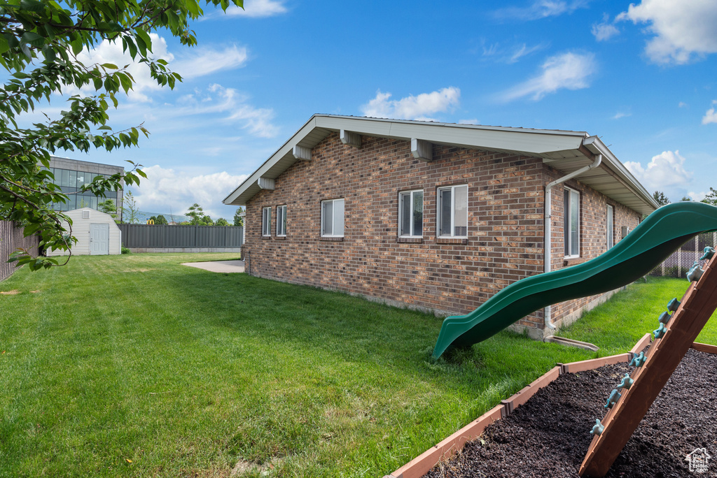 View of home's exterior with a shed, brick siding, and an outbuilding