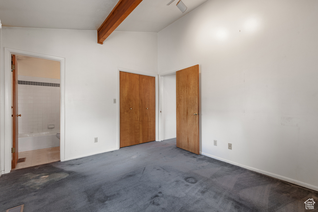 Unfurnished bedroom featuring beamed ceiling, baseboards, carpet, connected bathroom, and high vaulted ceiling