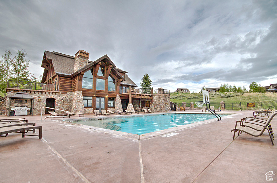 Community pool featuring a patio and fence