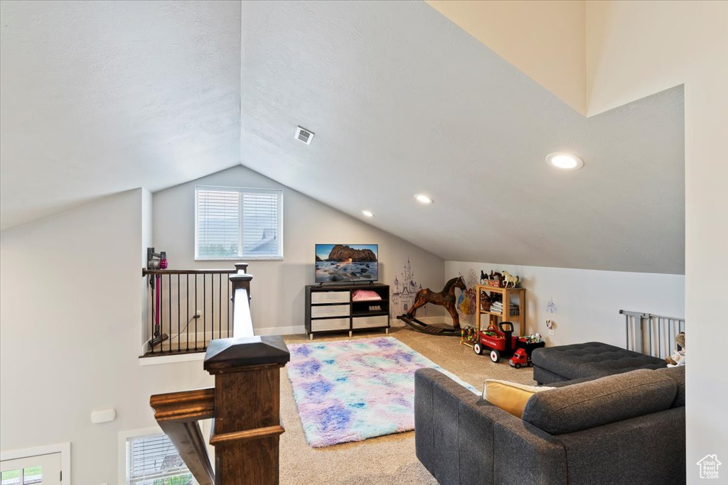 Carpeted living area featuring lofted ceiling and recessed lighting