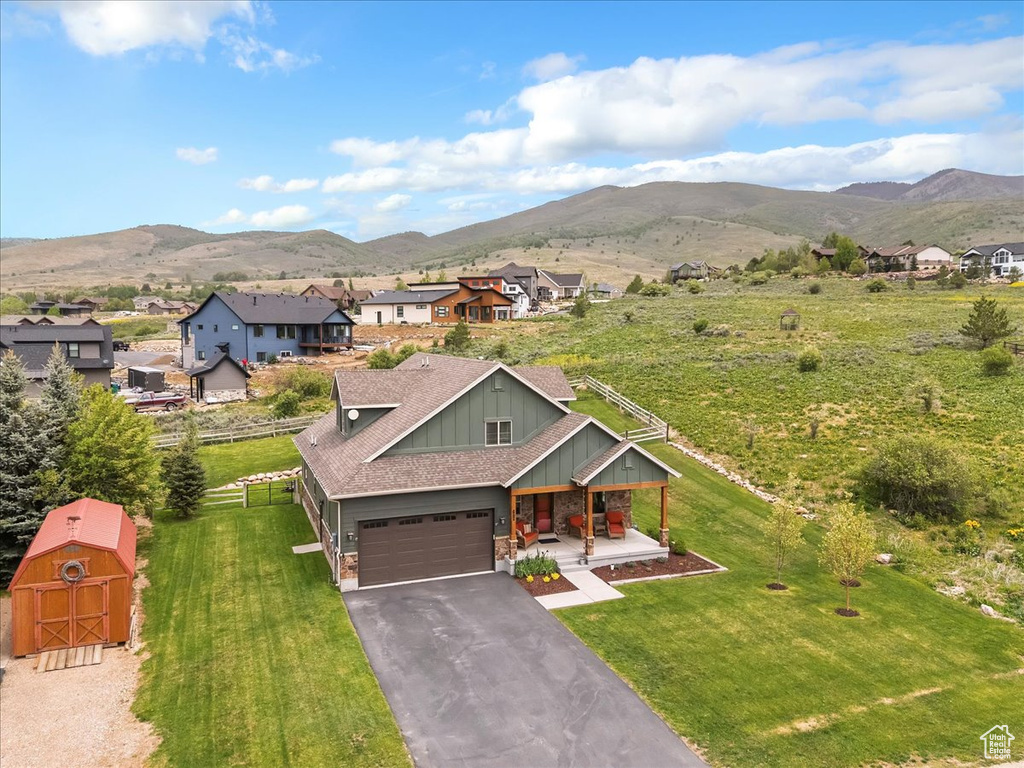 View of front of property with board and batten siding, covered porch, a mountain view, and roof with shingles