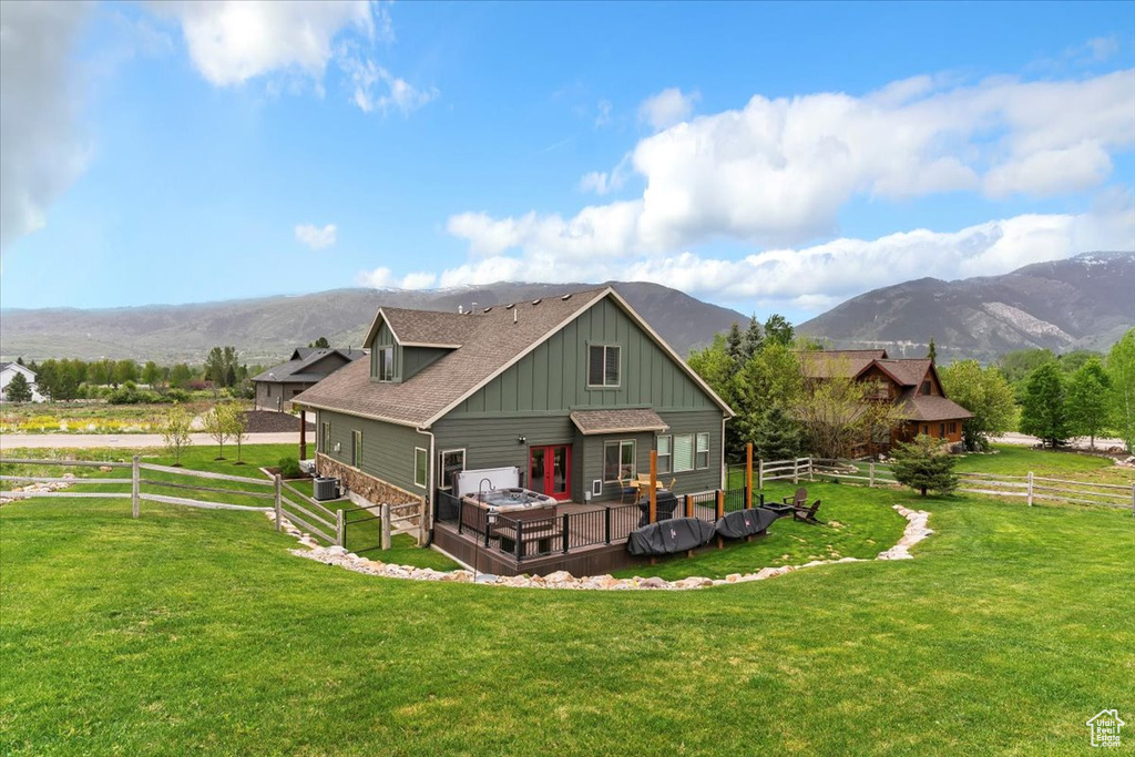 Back of house featuring board and batten siding, a deck with mountain view, roof with shingles, and french doors