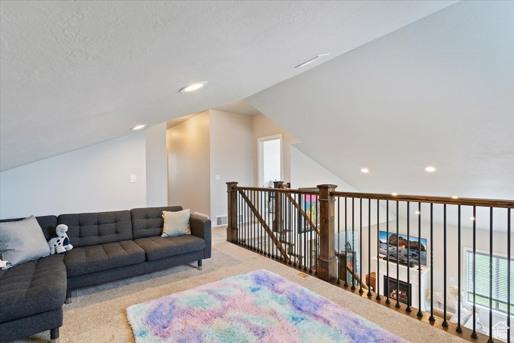 Carpeted living room featuring a textured ceiling and recessed lighting