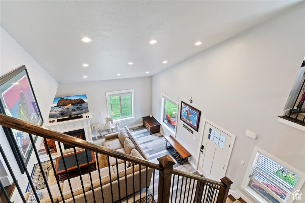 Stairway featuring recessed lighting, a lit fireplace, and baseboards