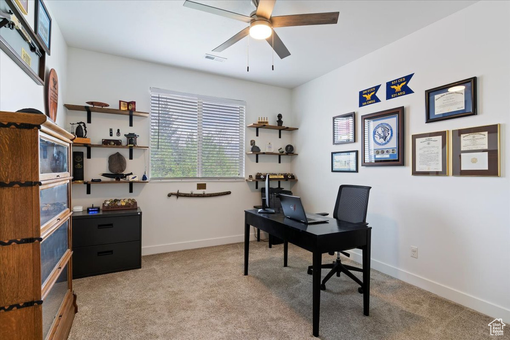 Office area featuring light carpet, a ceiling fan, and baseboards