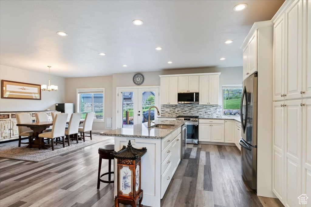 Kitchen with a sink, appliances with stainless steel finishes, plenty of natural light, dark wood finished floors, and recessed lighting