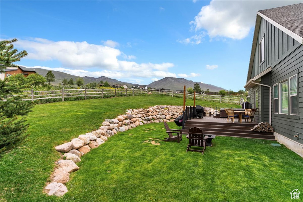 View of yard with a deck with mountain view