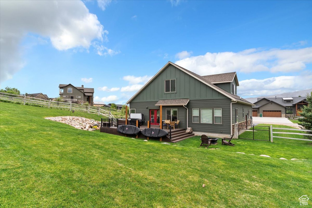 Rear view of property featuring board and batten siding and a deck