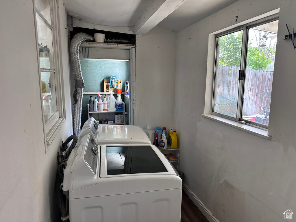 Laundry room featuring washing machine and dryer, wood finished floors, and baseboards