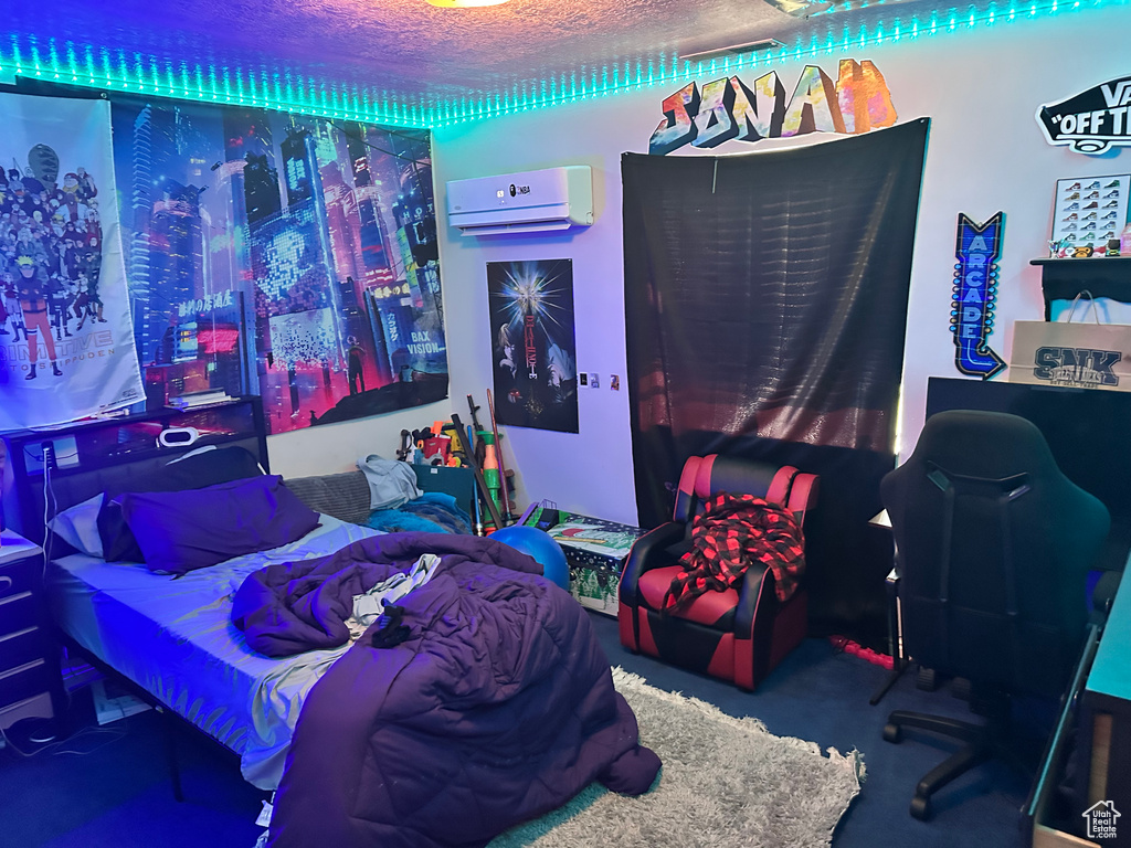 Bedroom featuring a wall mounted air conditioner and a textured ceiling