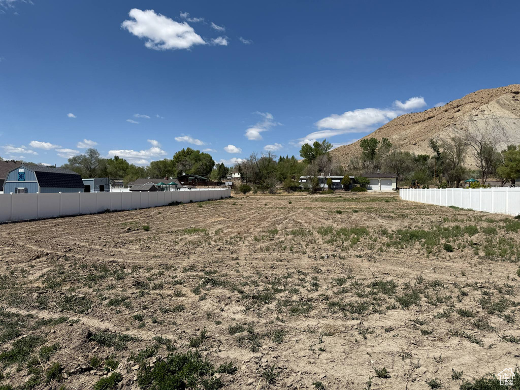 View of yard with a mountain view and fence