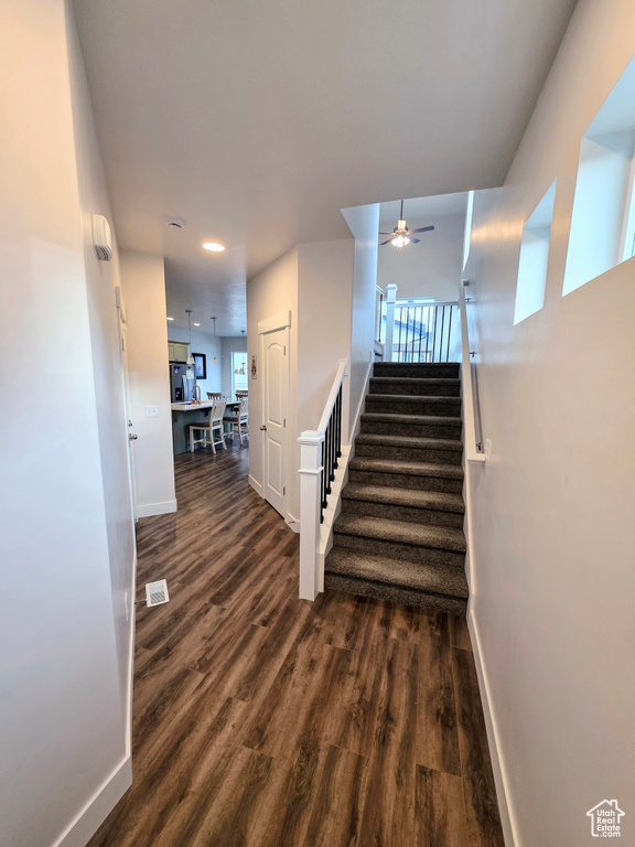 Staircase with baseboards, ceiling fan, wood finished floors, and recessed lighting